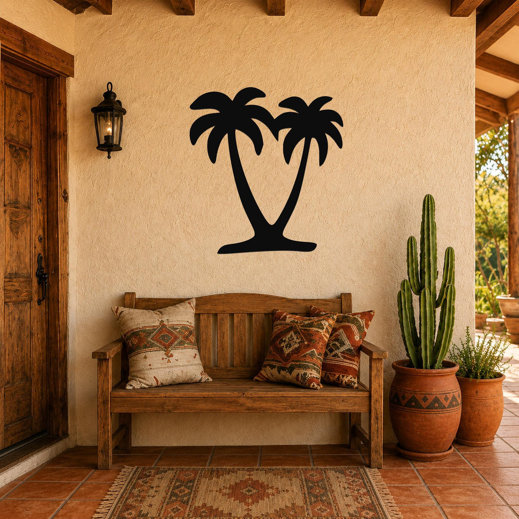 Black metal palm tree wall art silhouette with two fronds, mounted on a stucco wall above a wooden bench in a patio entryway.
