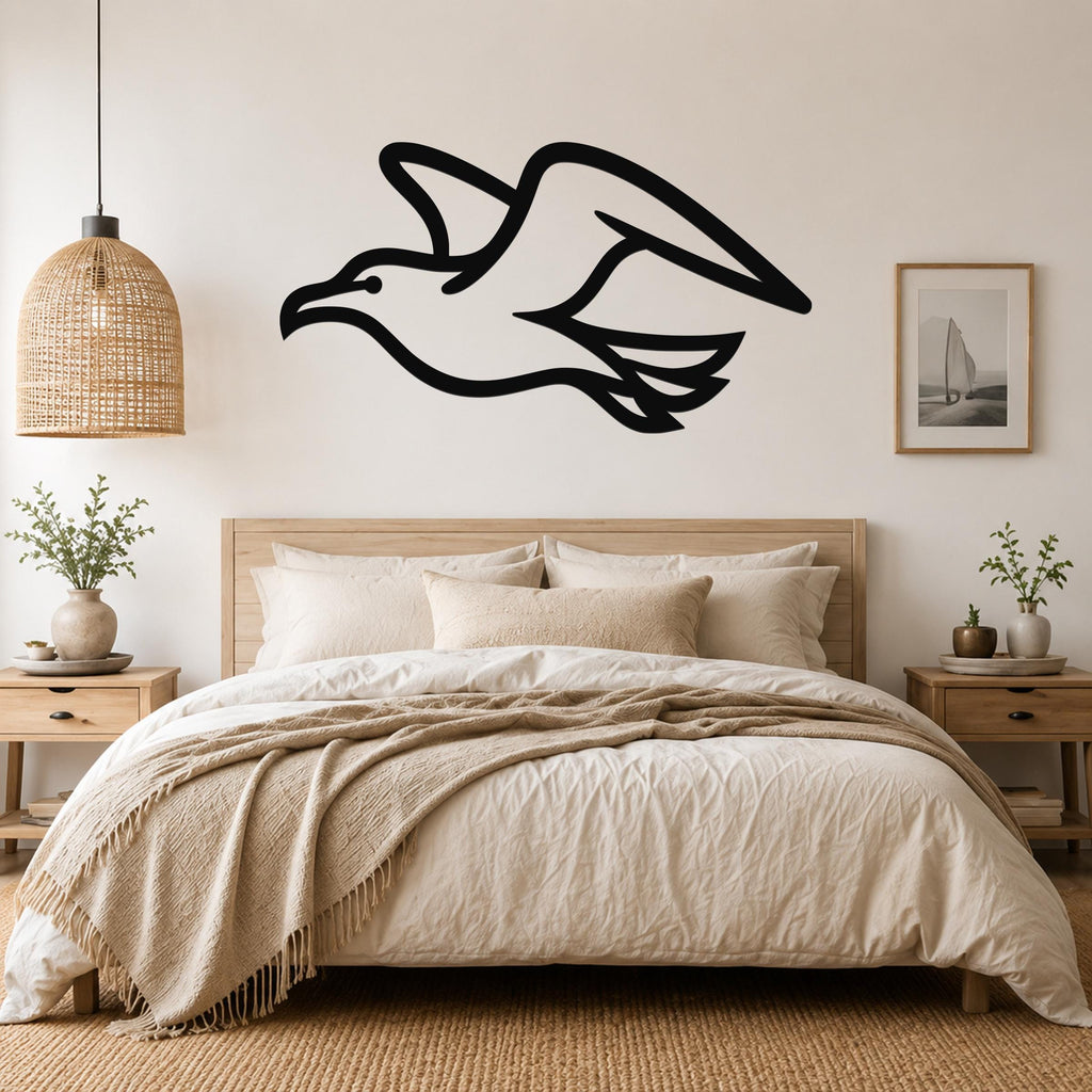 Black metal seagull wall art with a silhouette cutout design, mounted above a bed in a neutral bedroom.