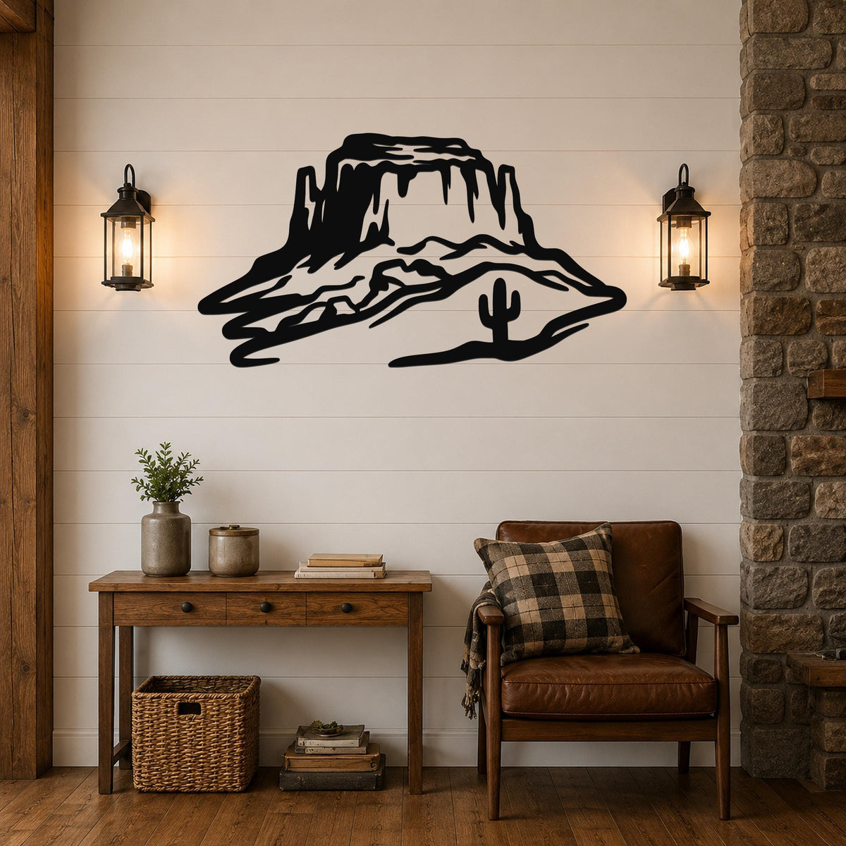 Black metal wall art silhouette of a desert mesa with a cactus, mounted on a shiplap wall above a wooden console table in a living room.