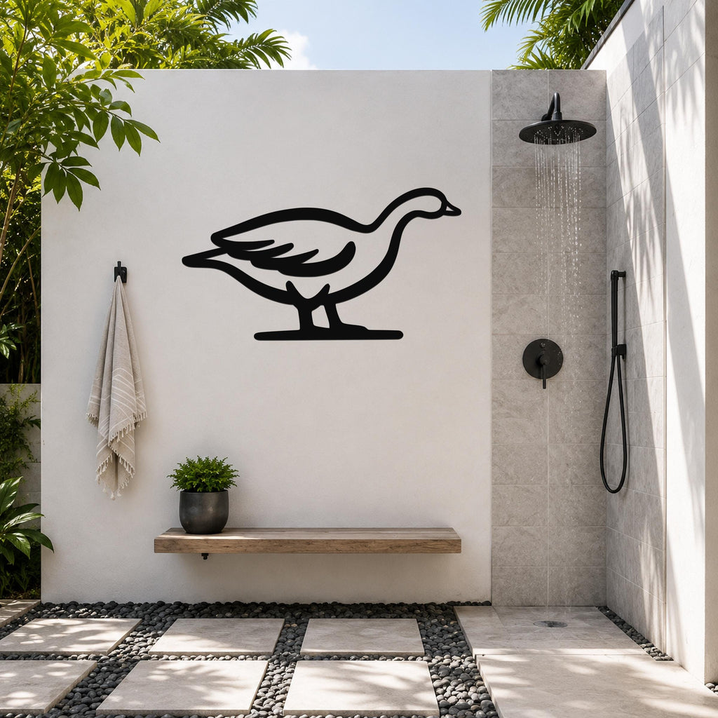 Black metal goose wall art silhouette mounted on a white outdoor shower wall, above a wooden bench with a potted plant.