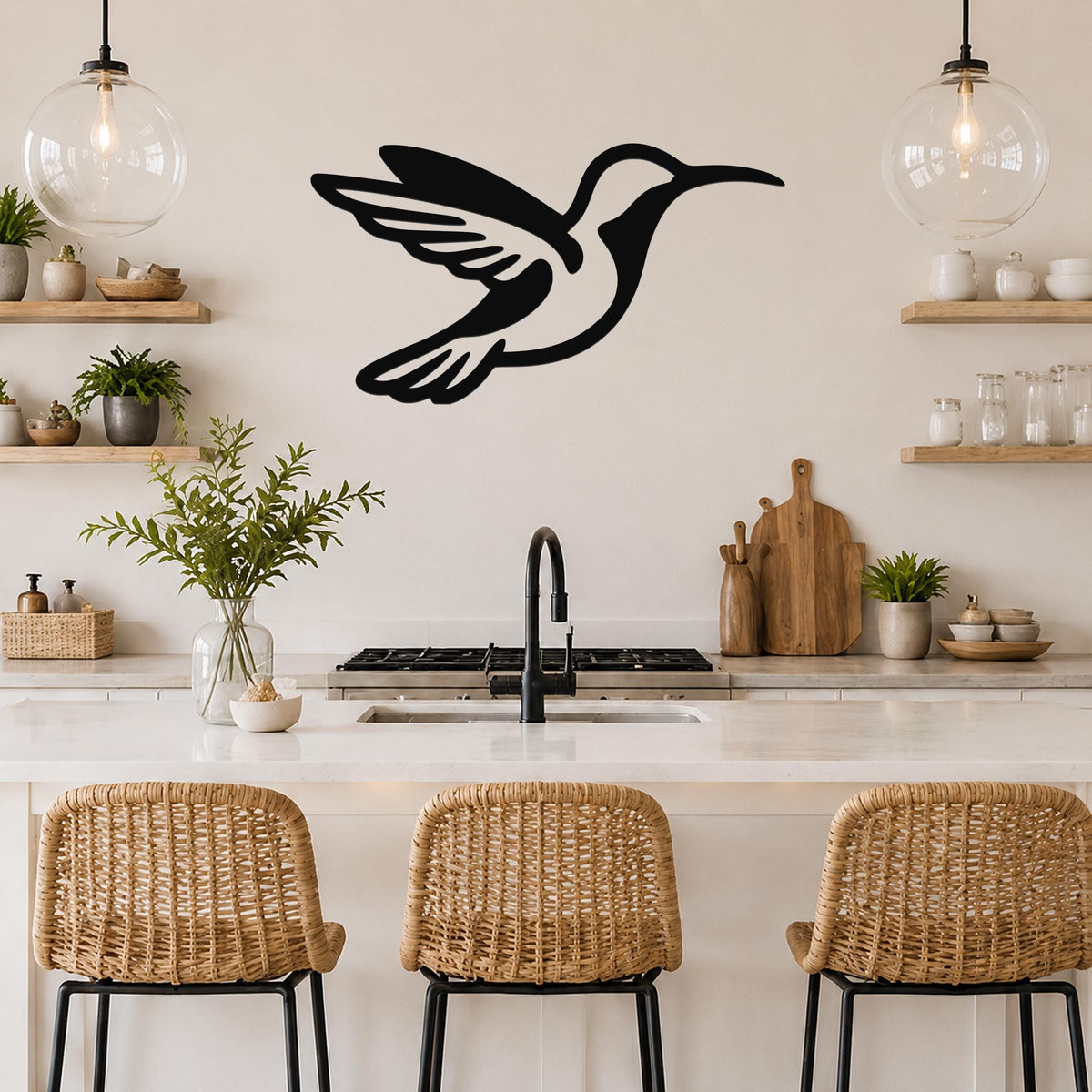 Black metal hummingbird wall art with wing and tail cutouts, mounted on a kitchen wall above a counter.