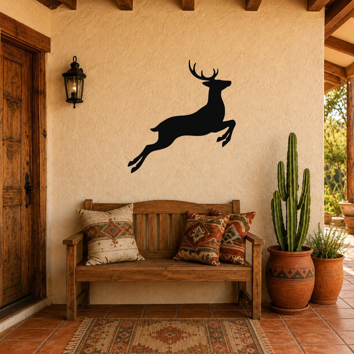 Black metal jumping deer wall art silhouette mounted on a stucco wall above a wooden bench in a rustic patio entryway.