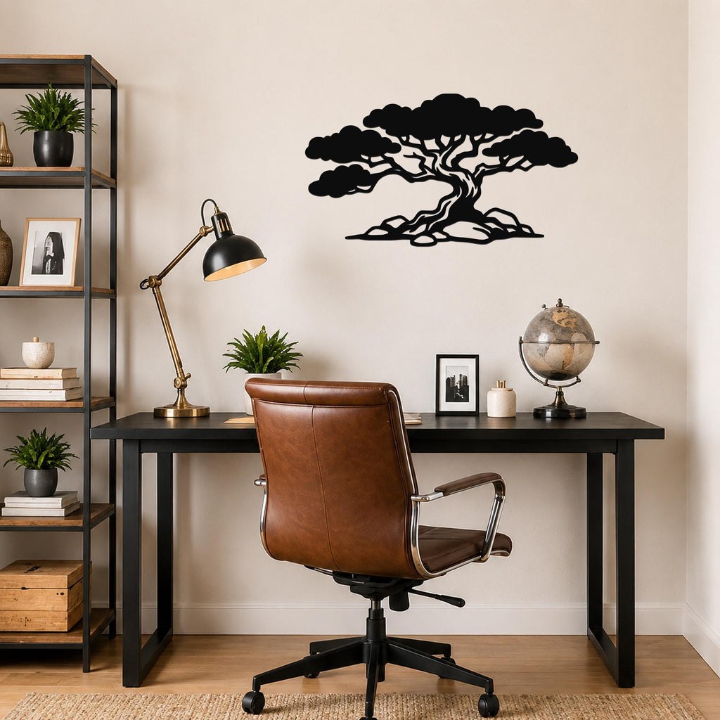 Black metal juniper tree wall art with wind-sculpted silhouette and visible root detail, mounted on a wall above a black desk in a home office.