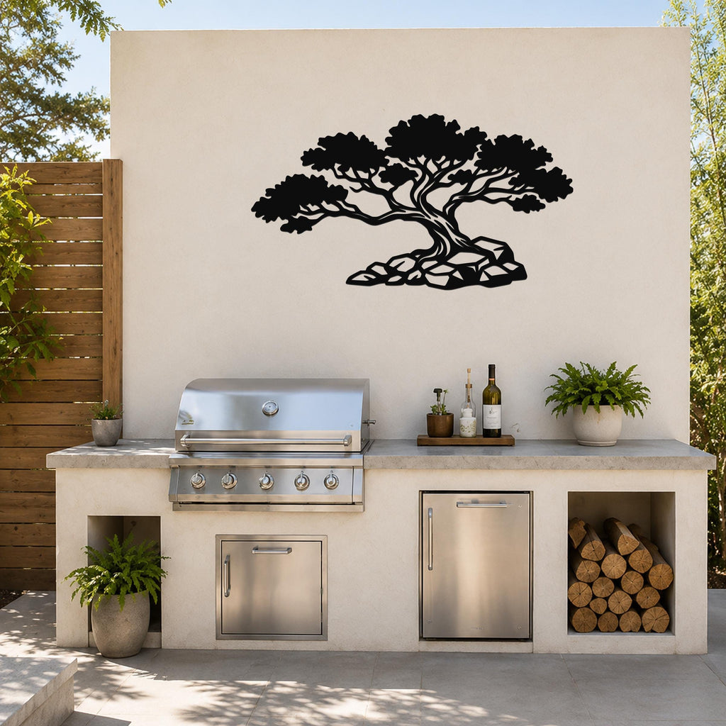 Black metal wall art in a bonsai tree silhouette with visible branch and root cutouts, mounted on a light-colored outdoor wall above a kitchen counter.