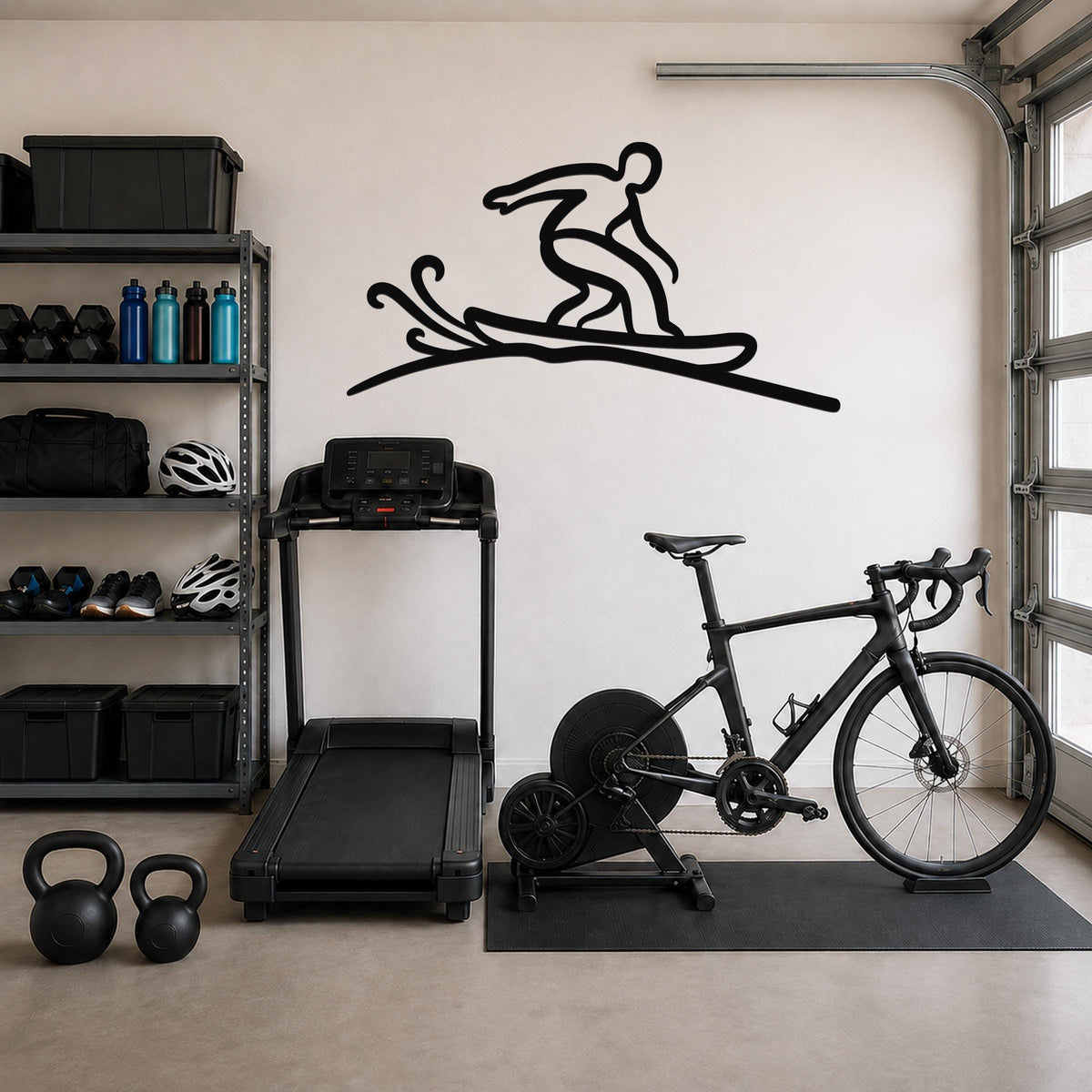 Black metal wall art silhouette of a snowboarder on a wave, mounted on a garage wall above a treadmill and bicycle.