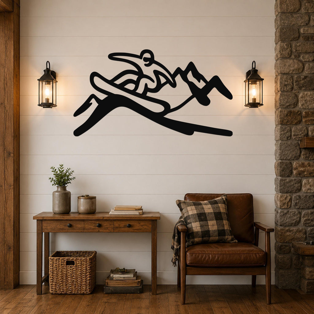 Black metal wall art silhouette of a snowboarder in motion, mounted above a wooden console table in a living room with shiplap walls and lanterns.