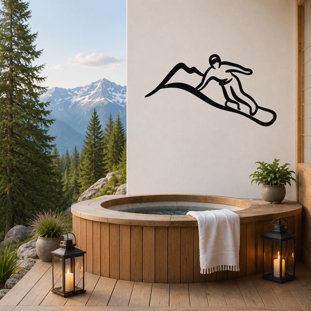 Black metal wall art silhouette of a snowboarder in motion, mounted on a white wall above a wooden hot tub on a mountain-view deck.