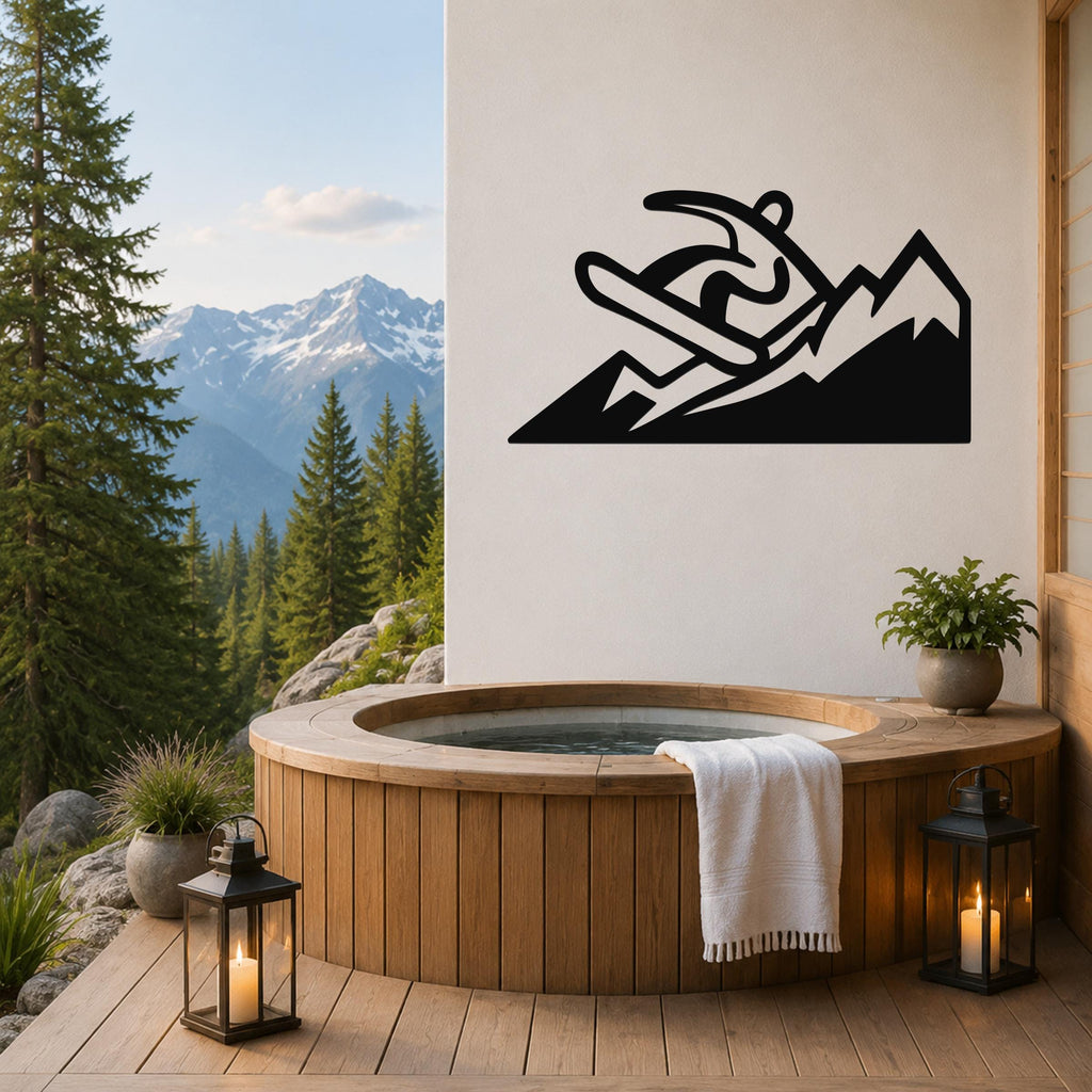 Black metal wall art featuring a snowboarder silhouette on a mountain, mounted on a white wall above a wooden hot tub on a deck with a mountain view.