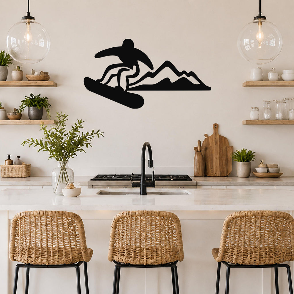 Black metal wall art silhouette of a snowboarder in motion above a mountain range, mounted on a kitchen wall above a counter.