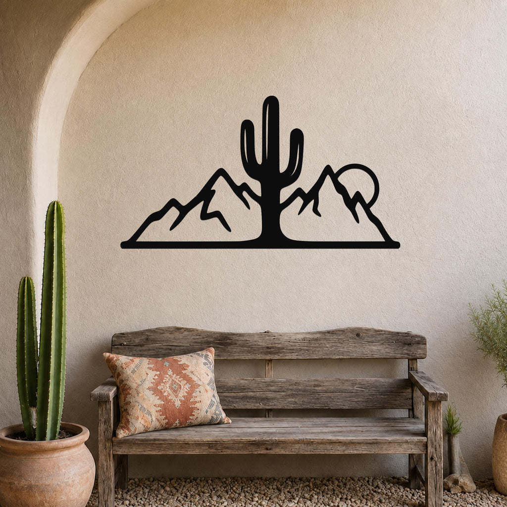 Black metal wall art silhouette of a saguaro cactus and mountains, mounted on a beige stucco wall above a wooden bench in a desert-themed entryway.