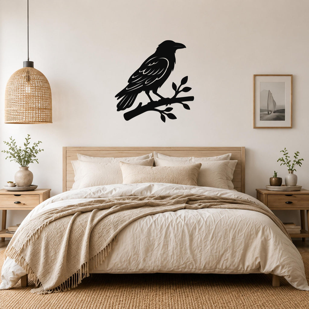 Black metal raven wall art silhouette perched on a branch, mounted above a bed in a neutral bedroom.