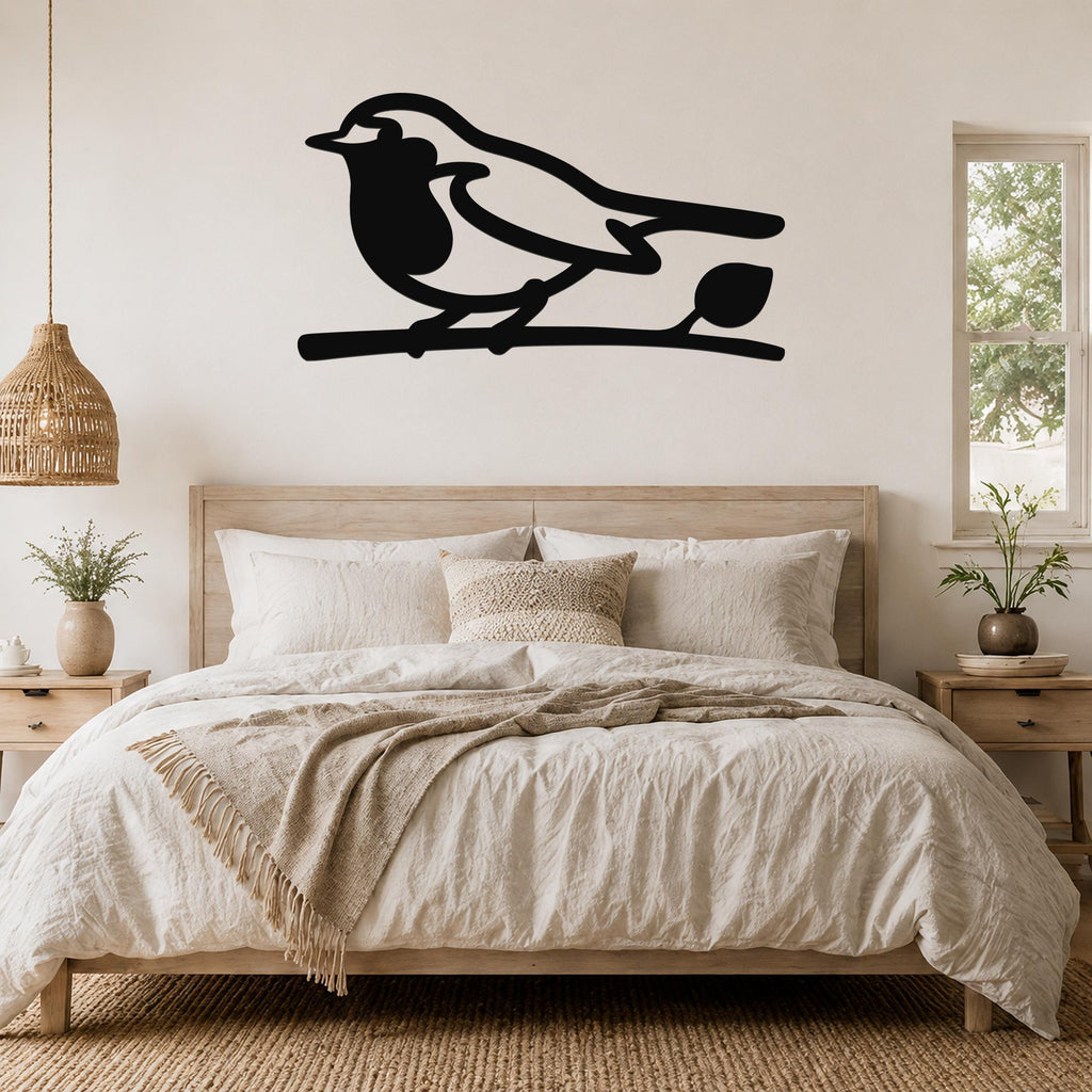 Black metal robin wall art silhouette perched on a branch, mounted above a bed in a neutral bedroom.