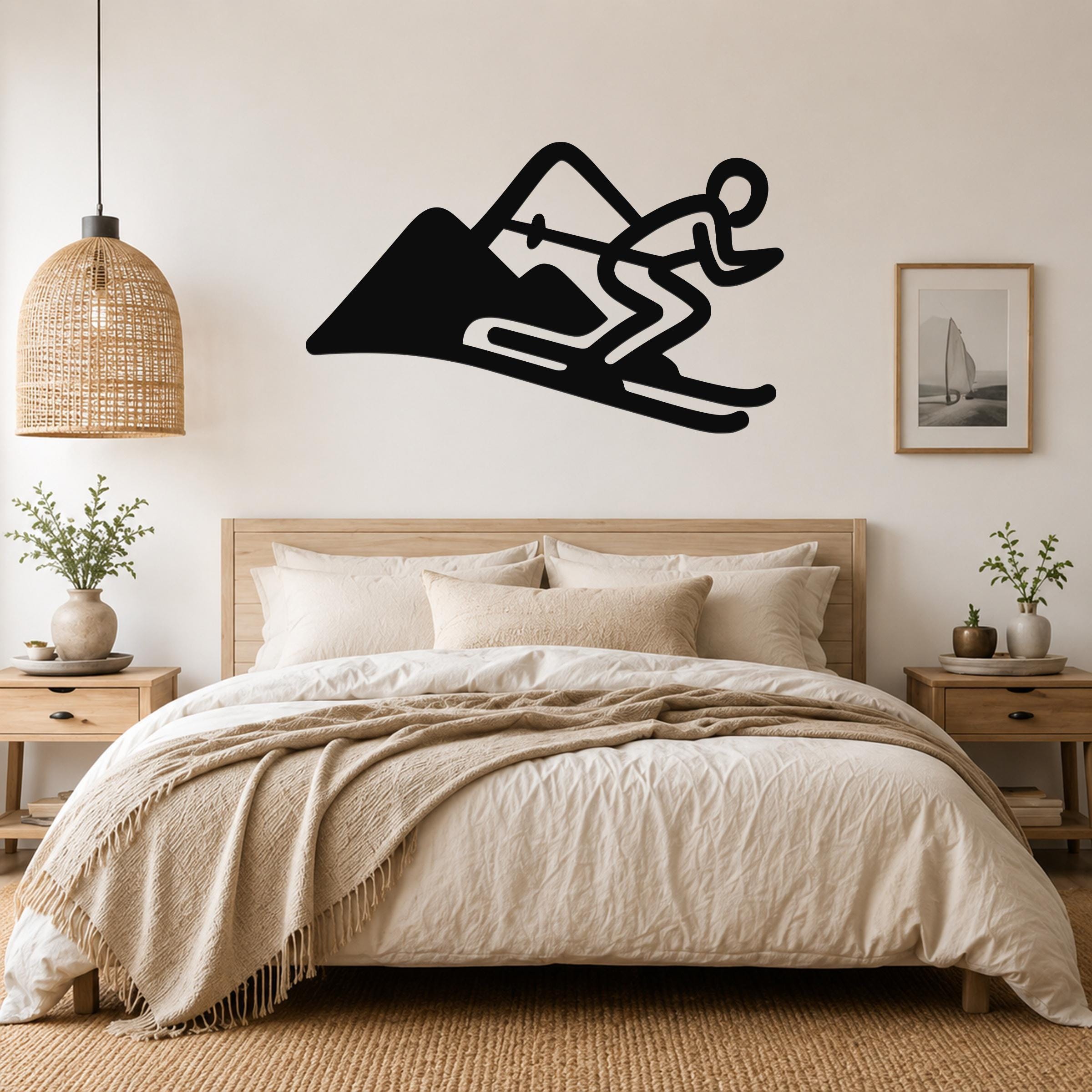 Black metal wall art featuring a skier silhouette in motion on a mountain, mounted above a bed in a bedroom.