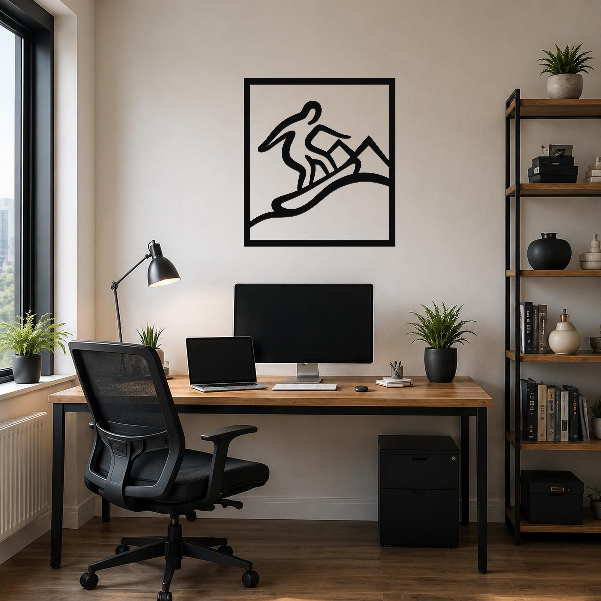 Black metal wall art with a snowboarder silhouette in motion, mounted above a wooden desk in a home office.
