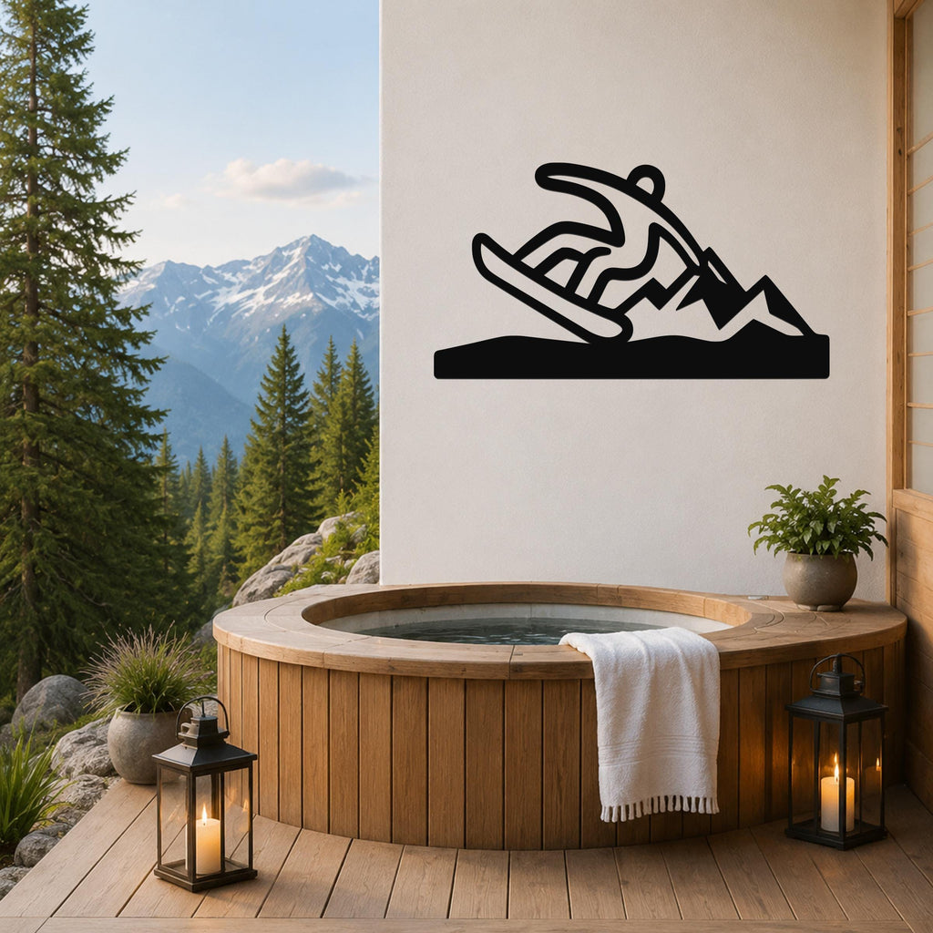 Black metal wall sculpture of a snowboarder in motion, mounted on a white wall above a wooden hot tub on a mountain-view deck.
