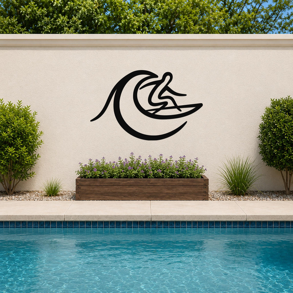 Black metal surfer wall art with wave cutout, mounted on an outdoor wall above a planter and pool.