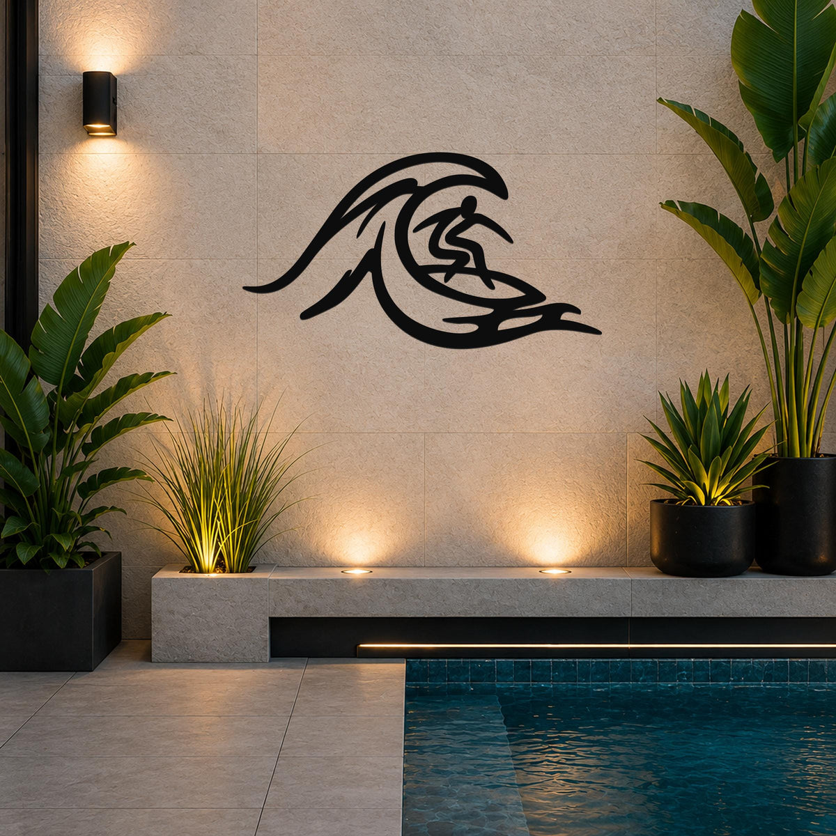 Black metal surfer wall art with wave cutout design, mounted on a tiled wall above a poolside planter in a modern outdoor space.