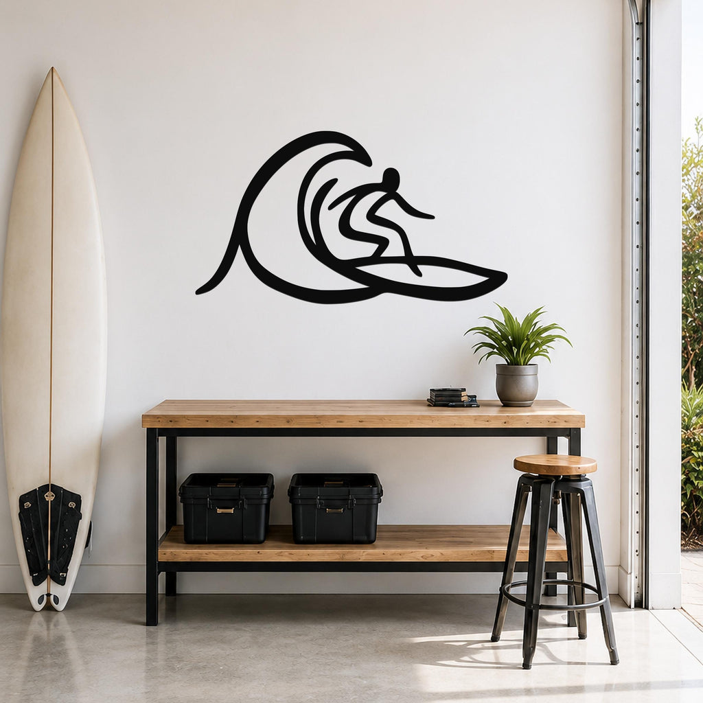 Black metal surfer wall art with wave silhouette cutout, mounted above a wooden console table in a modern entryway.