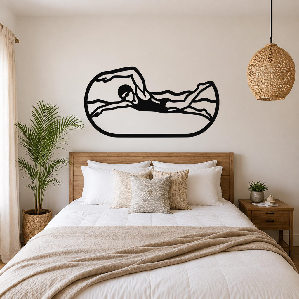 Black metal swimmer wall art with motion-line cutouts, mounted above a bed in a neutral bedroom.