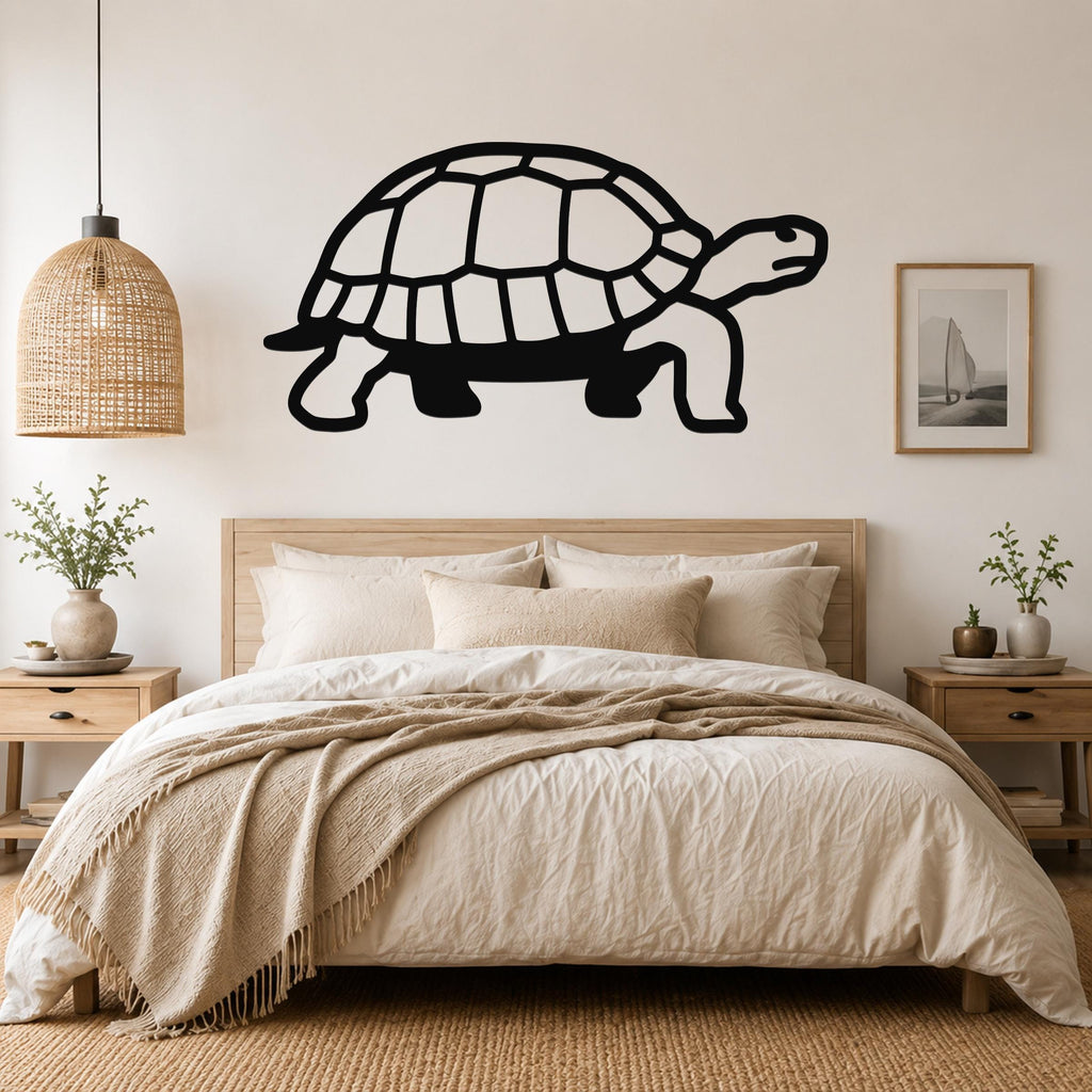 Black metal tortoise wall art with a cutout shell design, mounted above a wooden bed in a neutral bedroom.