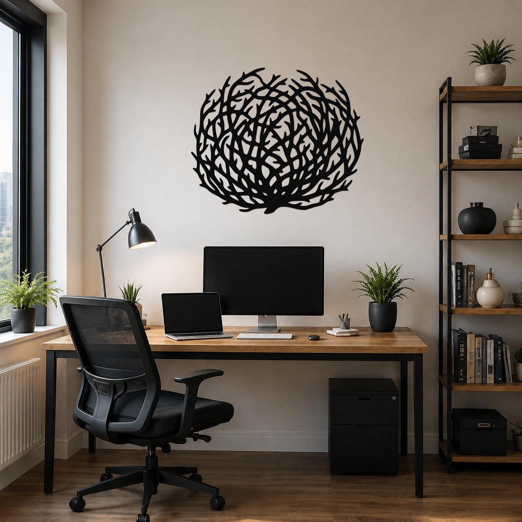 Black metal wall art with a circular, branch-like silhouette design, mounted above a wooden desk in a home office.
