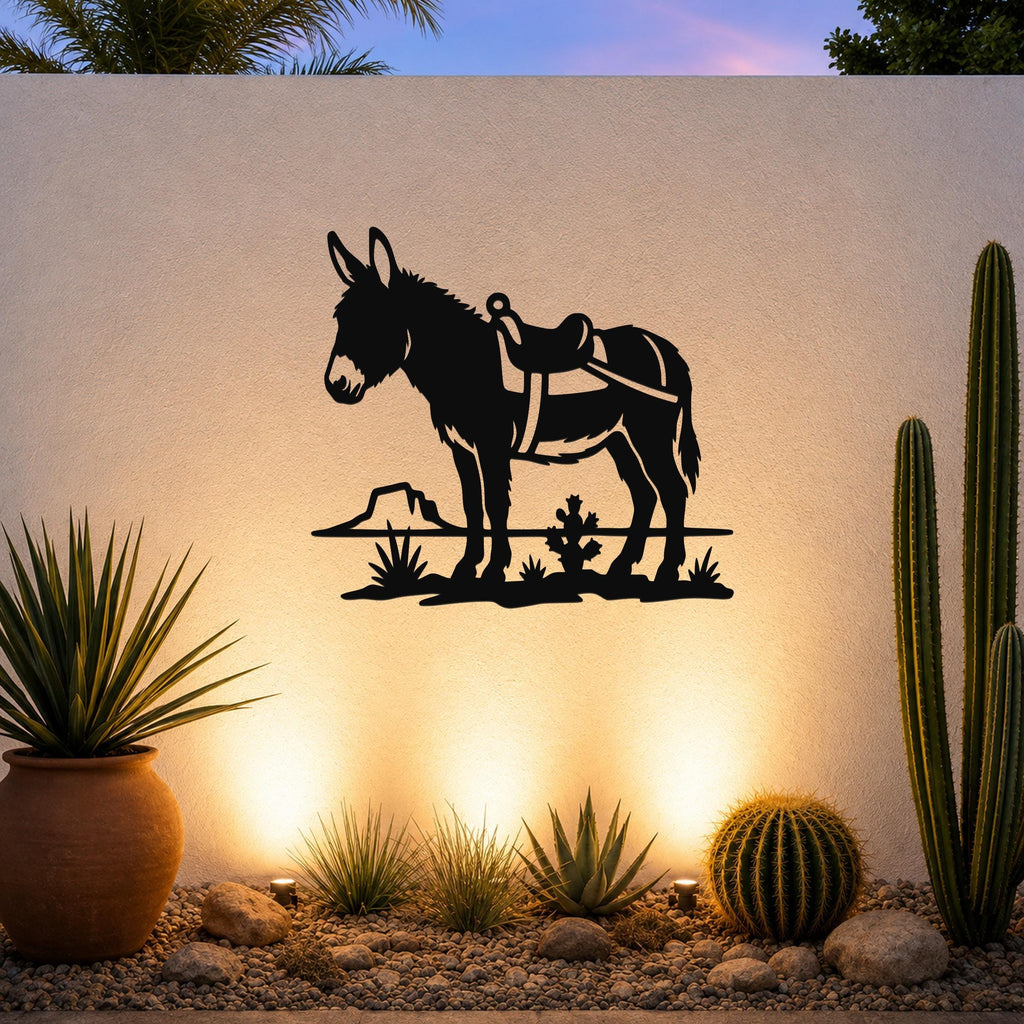 Black metal wall art silhouette of a burro with saddle, mounted on an outdoor wall above a desert garden with cacti and warm uplighting.