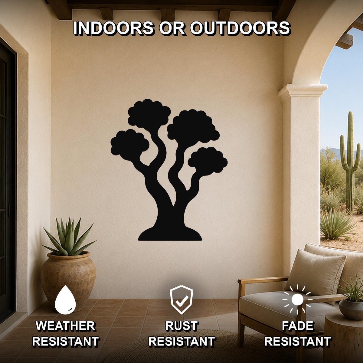 Black metal tree wall art with a silhouette design, mounted on a beige outdoor patio wall above a chair and potted plant.