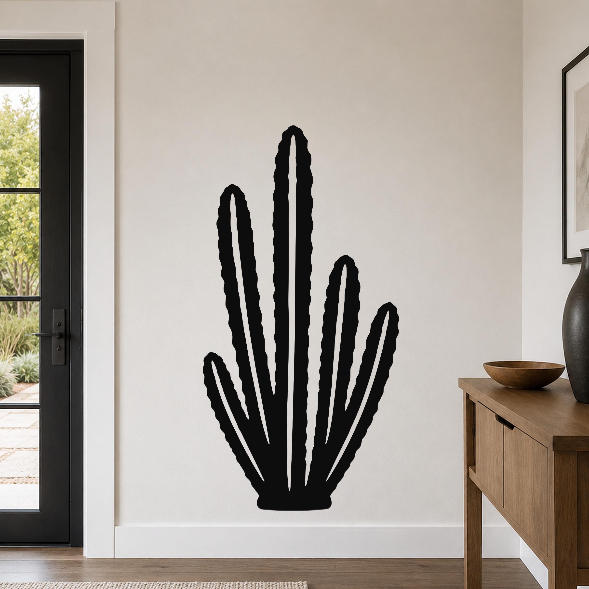 Black metal wall art cutout of an organ pipe cactus with multiple vertical arms, mounted on a light-colored wall in a modern entryway.