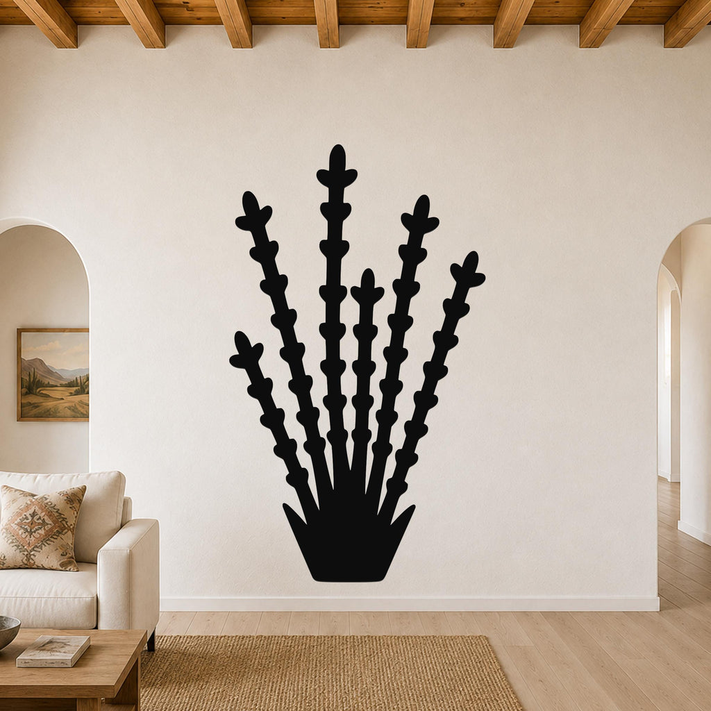 Black metal wall art silhouette of an ocotillo plant with multiple spiny stems, mounted on a living room wall above a sofa.