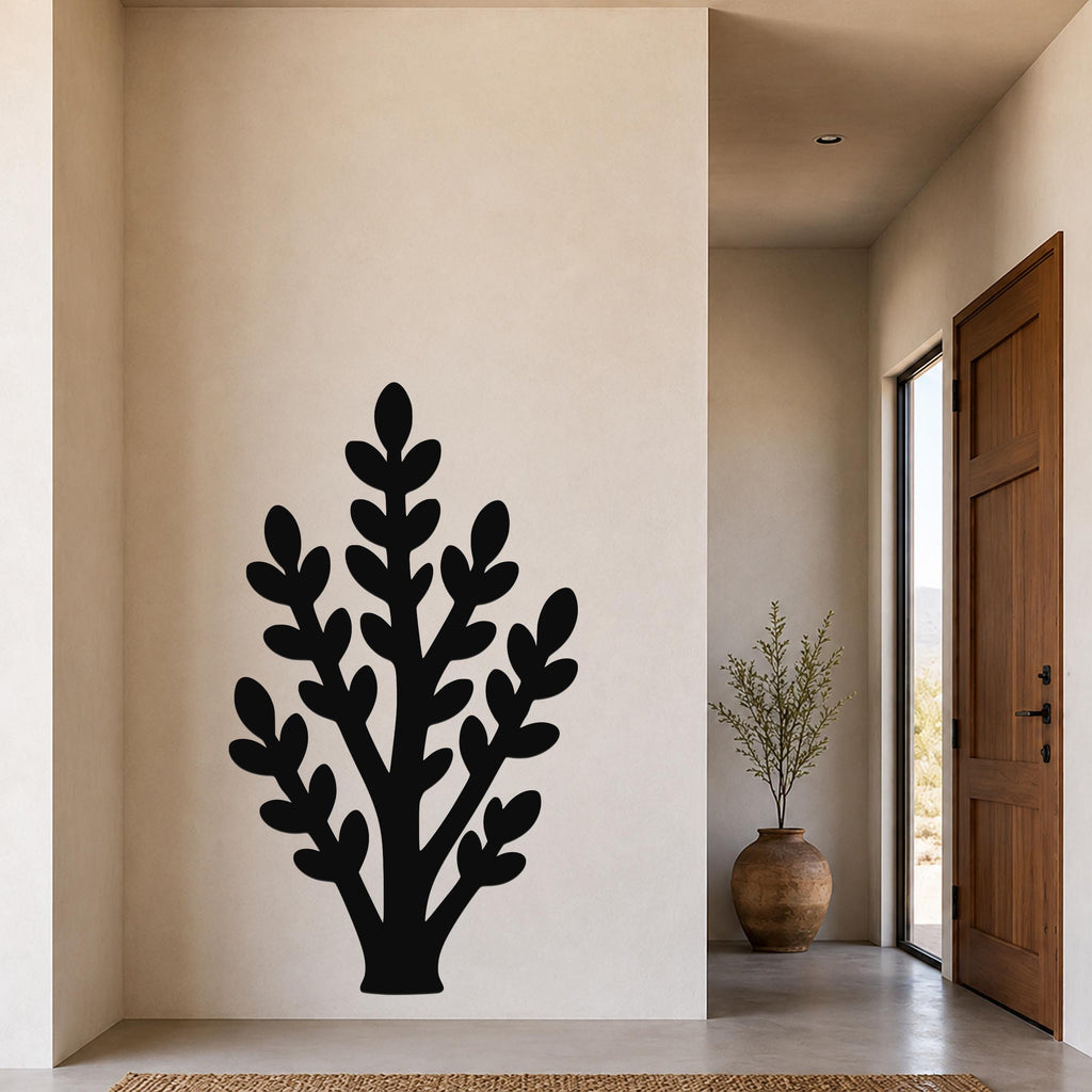 Black metal wall art in a silhouette of a jade plant with layered leaf cutouts, mounted on a beige wall in a modern entryway.