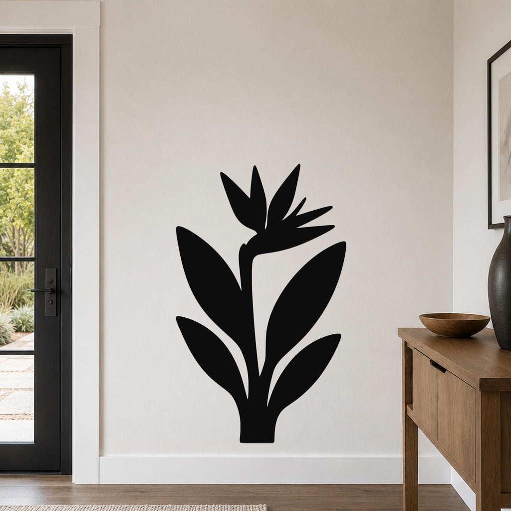 Black metal Bird of Paradise wall art with a clean botanical silhouette, mounted on a living room wall above a wooden console table.