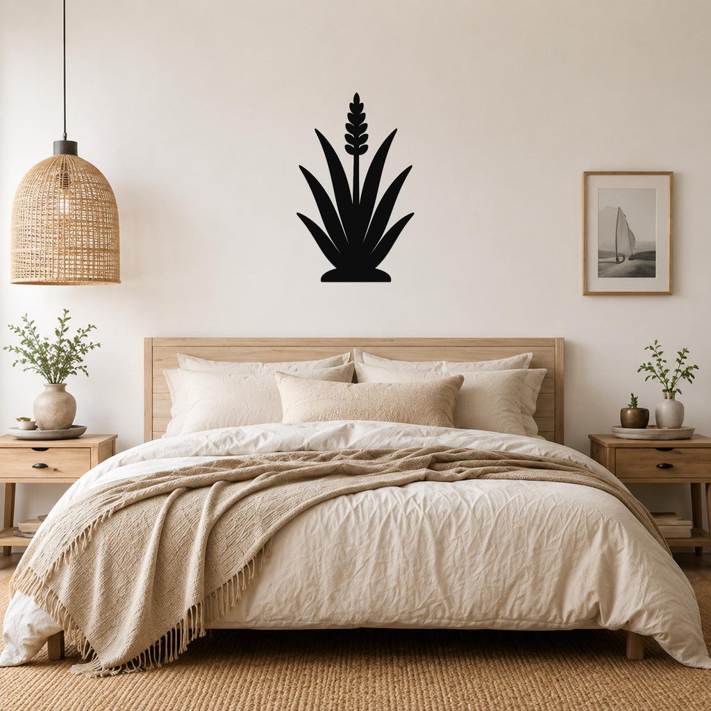 Black metal agave wall art with a flower spike cutout, mounted above a wooden bed in a neutral bedroom.