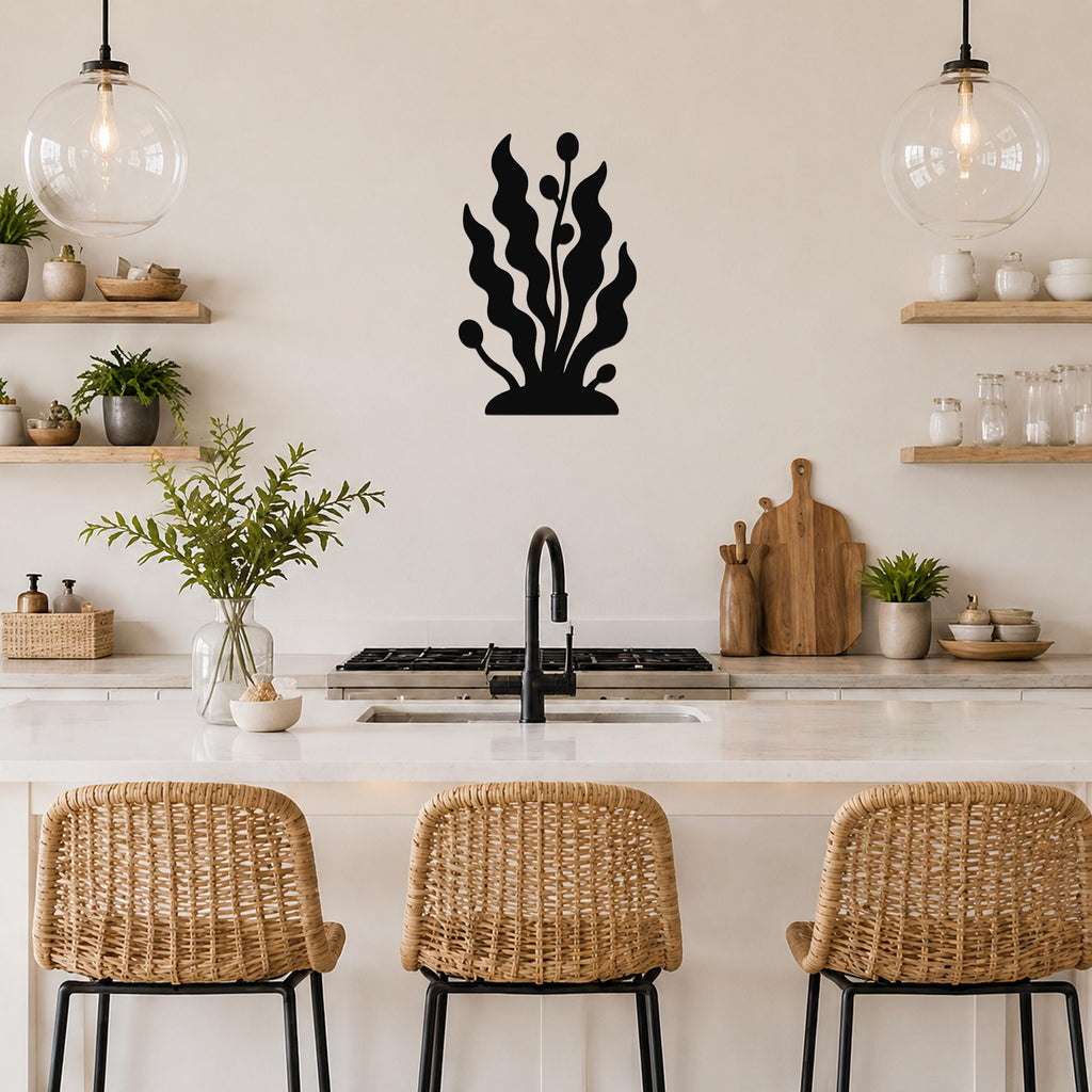Black metal wall art in a seaweed silhouette with wavy fronds and bulbous tips, mounted on a kitchen wall above a counter.