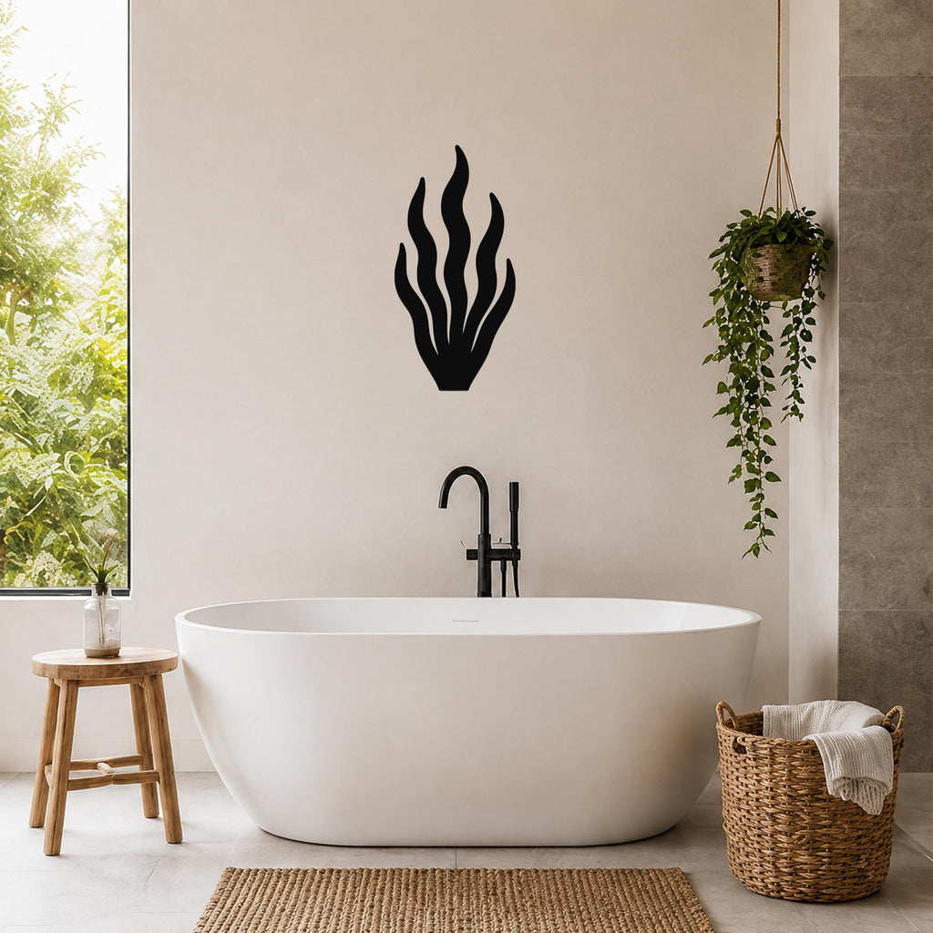 Black metal kelp wall art with flowing frond cutouts, mounted on a bathroom wall above a freestanding tub.