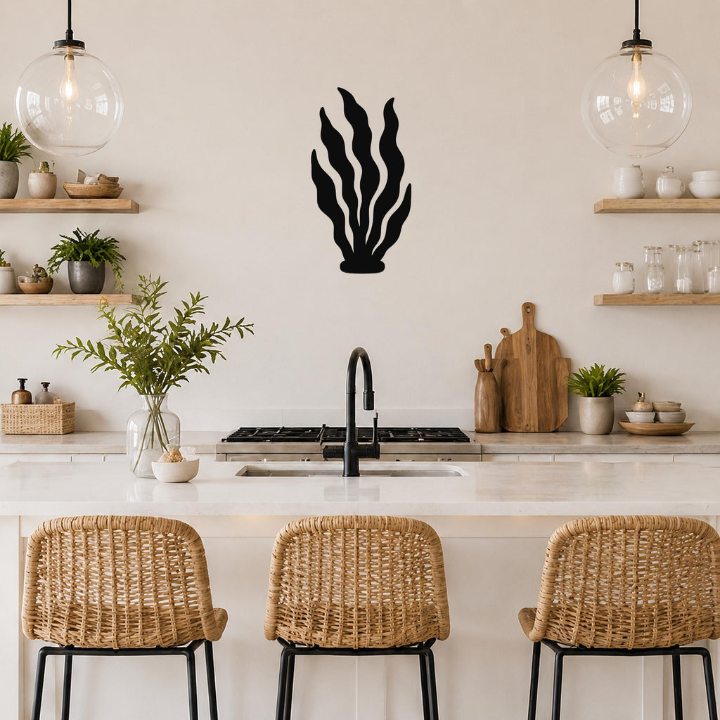 Black metal kelp wall art with flowing leaf cutouts, mounted on a kitchen wall above a counter.