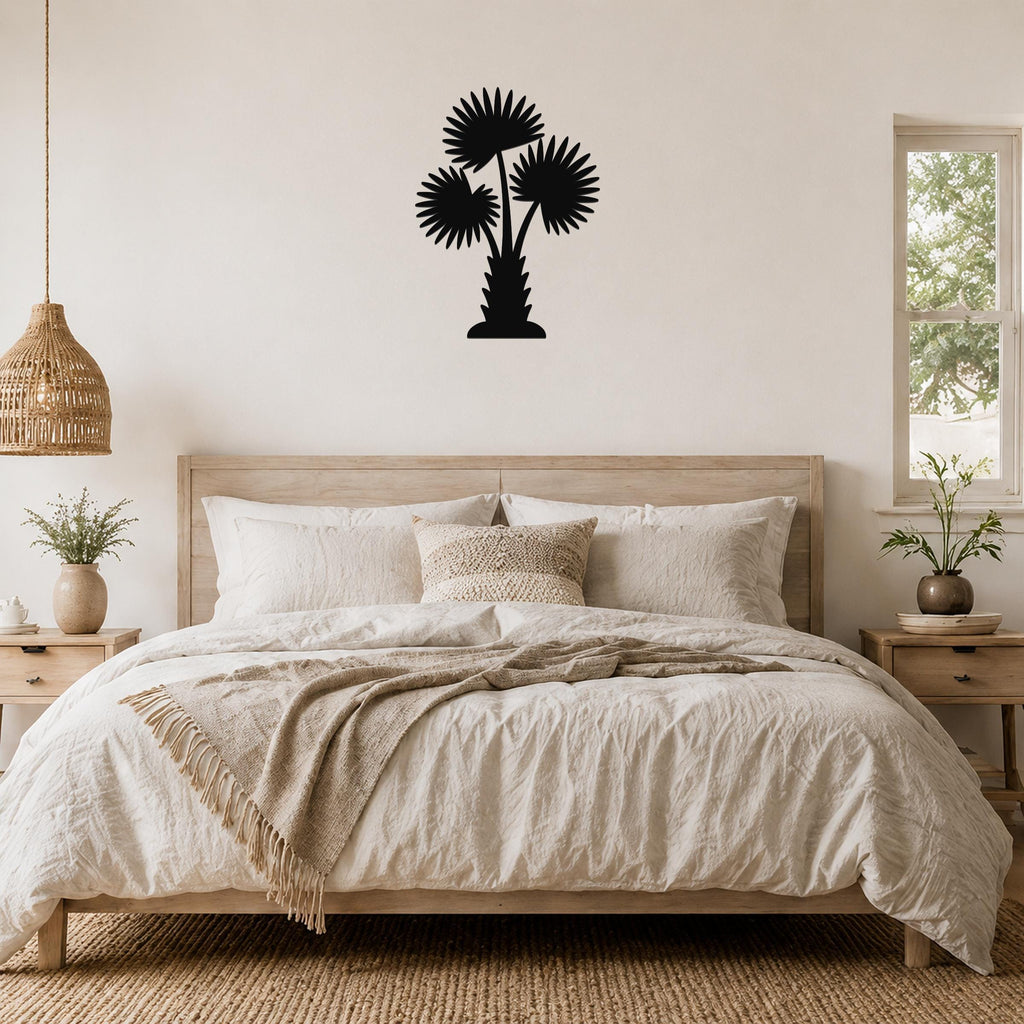 Black metal palm tree wall art with three fan-shaped fronds, mounted above a wooden bed in a neutral bedroom.