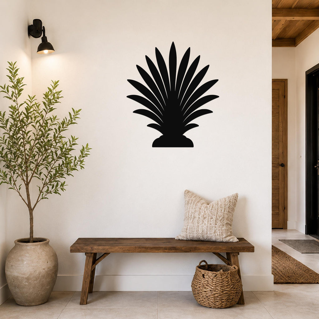 Black metal palm tree wall art silhouette mounted on a white wall above a wooden bench in a modern entryway.