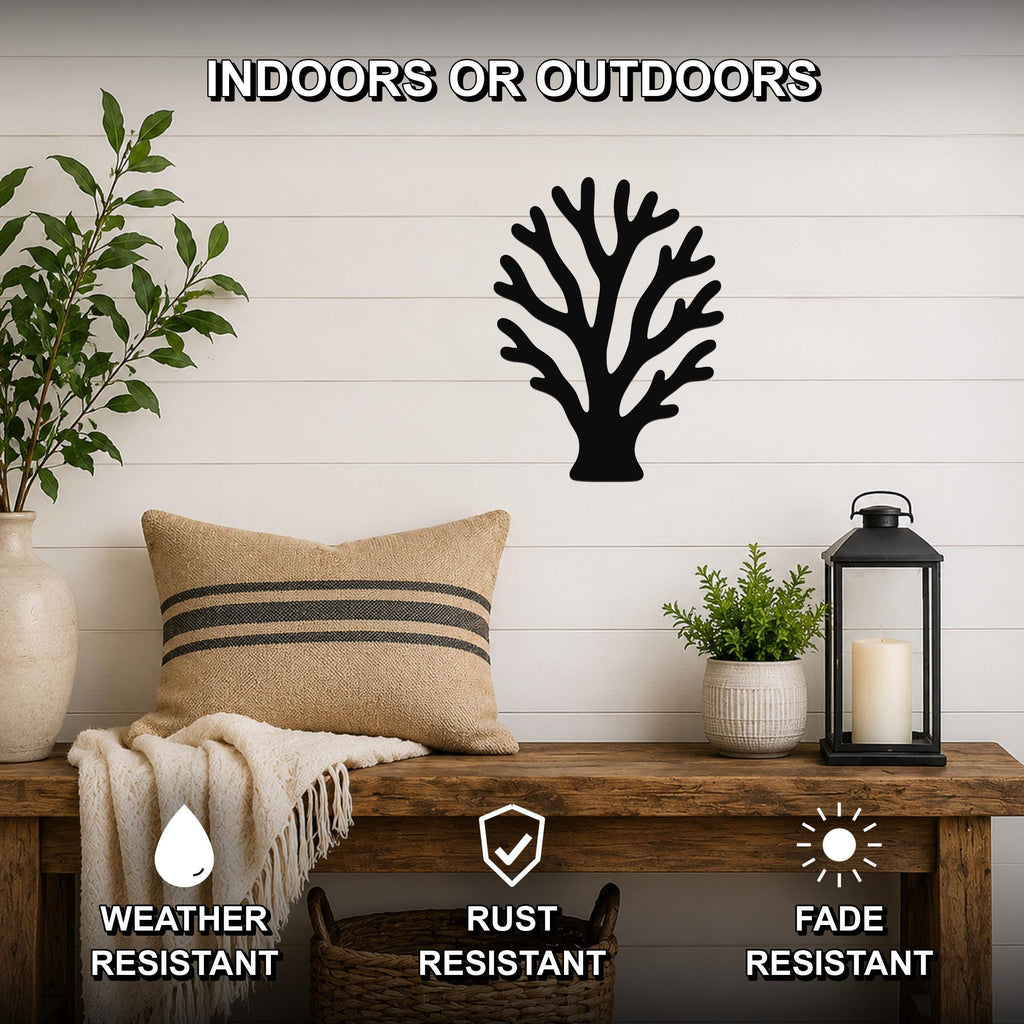 Black metal branching coral wall art with intricate cutout details, mounted on a white shiplap wall above a wooden bench in a living room.