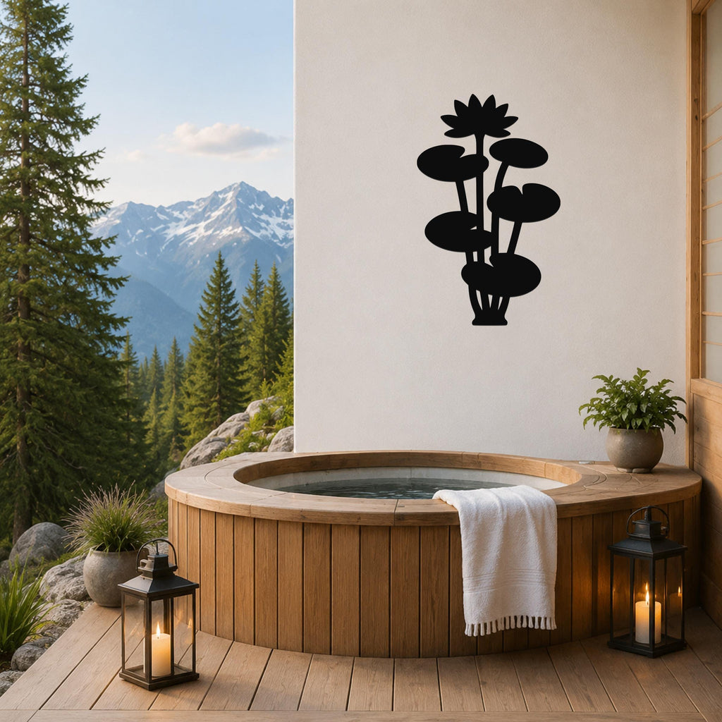 Black metal lotus water lily wall art with layered flower and leaf cutouts, mounted on a white wall above a wooden hot tub on a mountain-view patio.