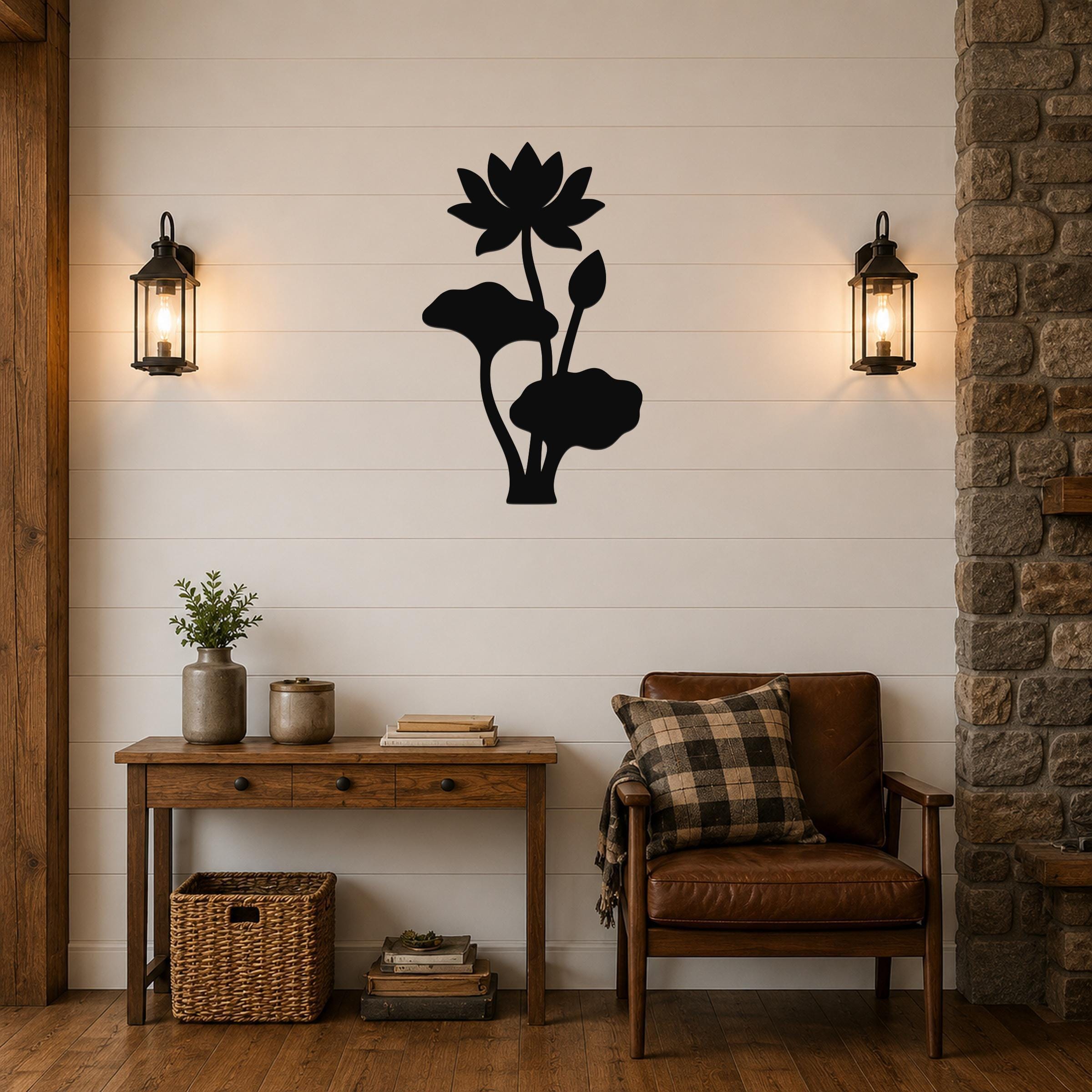 Black metal lotus flower wall art with leaf and bud cutouts, mounted on a shiplap wall above a wooden console table in a living room.