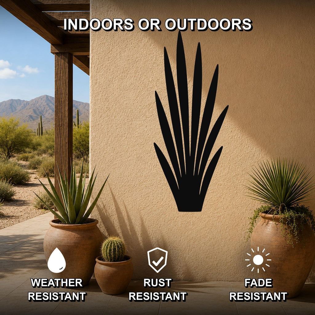 Black metal agave wall art silhouette mounted on a beige outdoor wall, displayed on a patio with potted plants and desert scenery in the background.