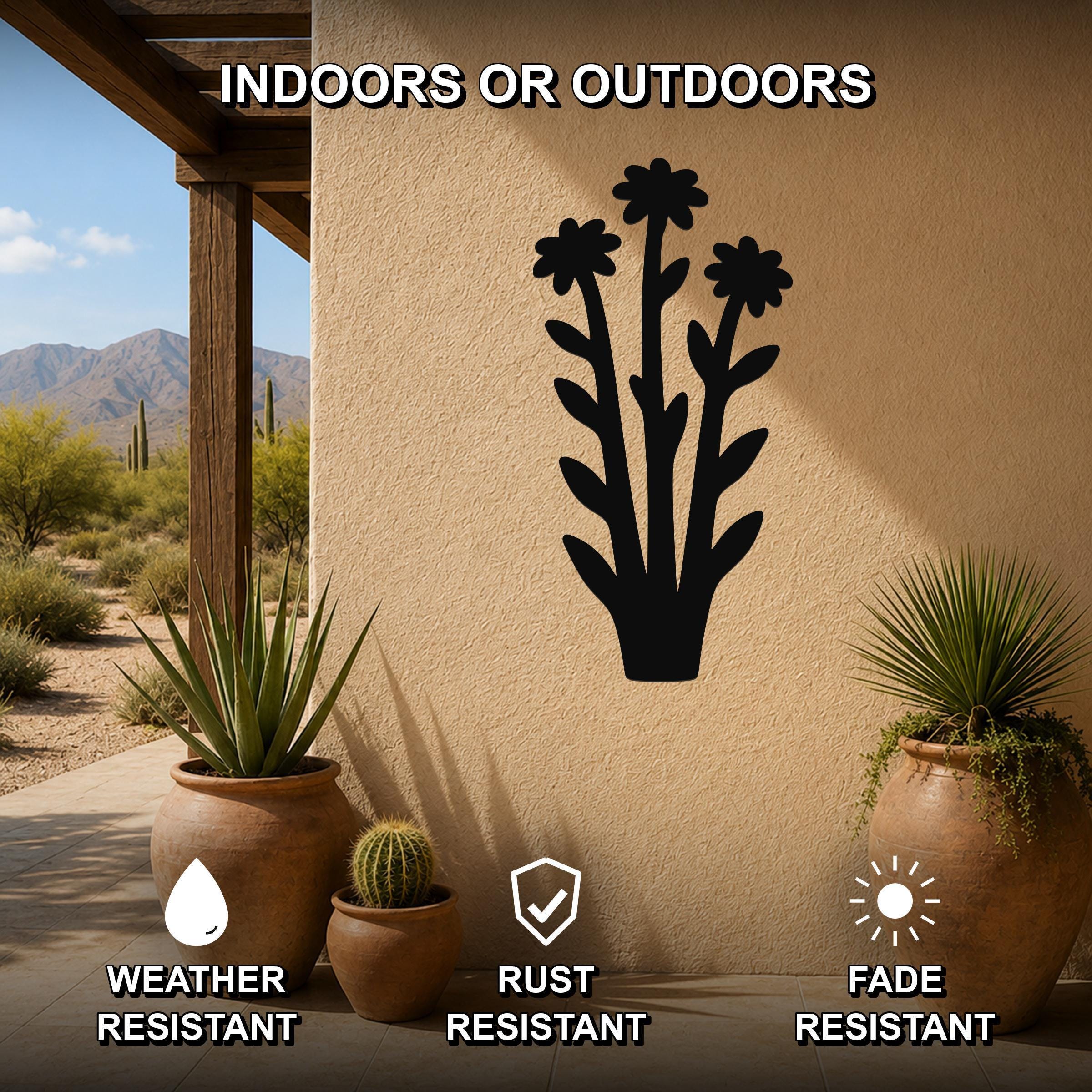 Black metal wildflower wall art with three flower cutouts and leafy stems, mounted on an outdoor patio wall above potted plants, weather, rust, and fade resistant.