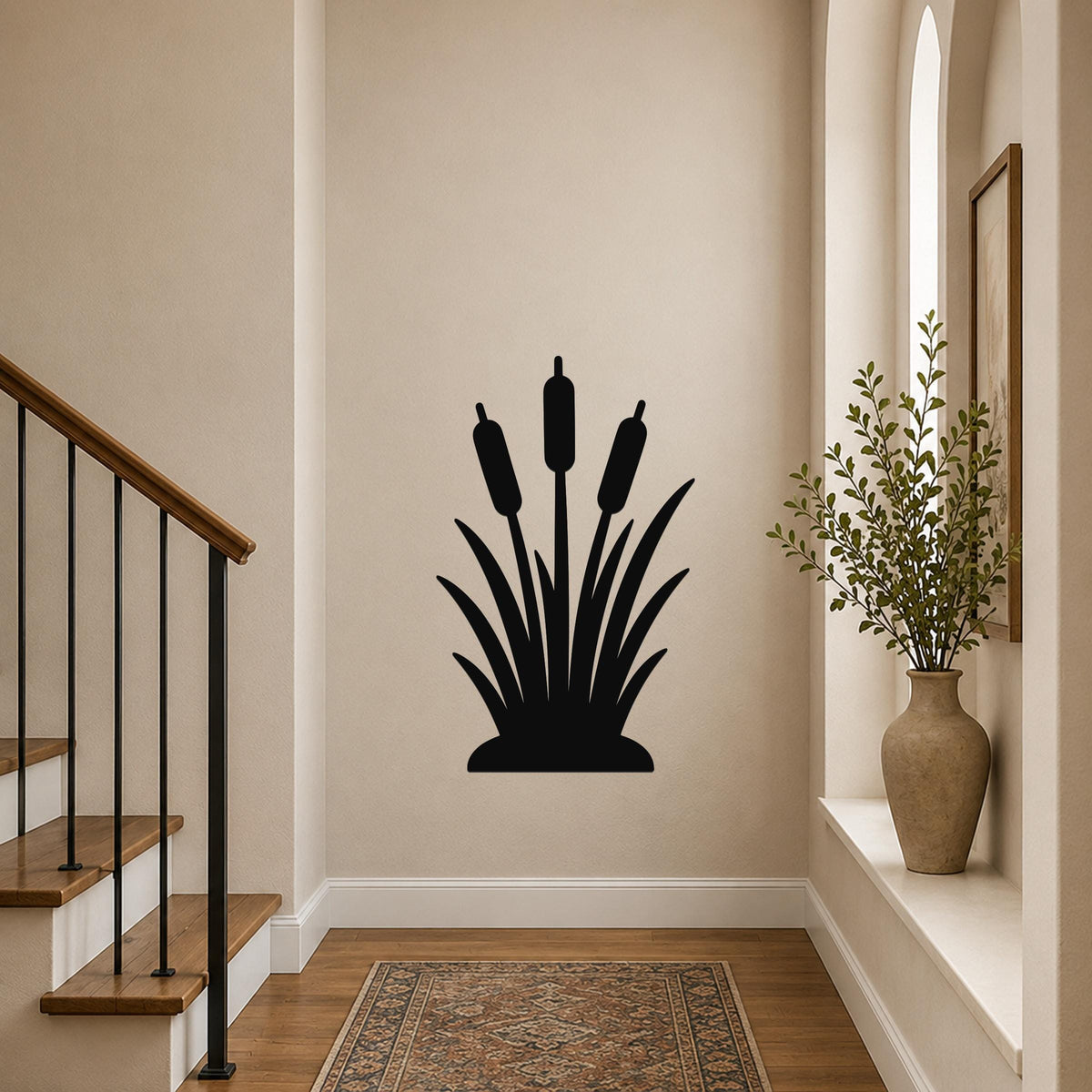 Black metal cattail wall art silhouette with three reeds and leafy base, mounted on a hallway wall above a patterned rug near a staircase.