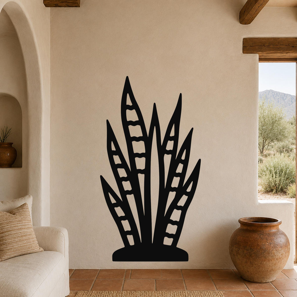 Black metal snake plant wall art with leaf cutouts, mounted on a beige living room wall above a sofa.