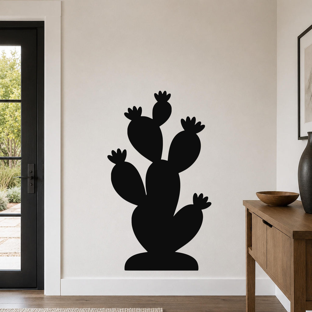 Black metal cactus wall art with multiple paddle-shaped arms and flower cutouts, mounted on a white wall in a modern living room.