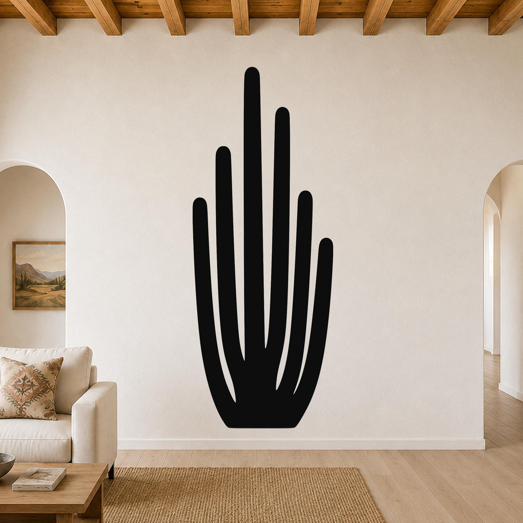 Black metal wall art in the shape of an organ pipe cactus, mounted on a living room wall above a sofa.