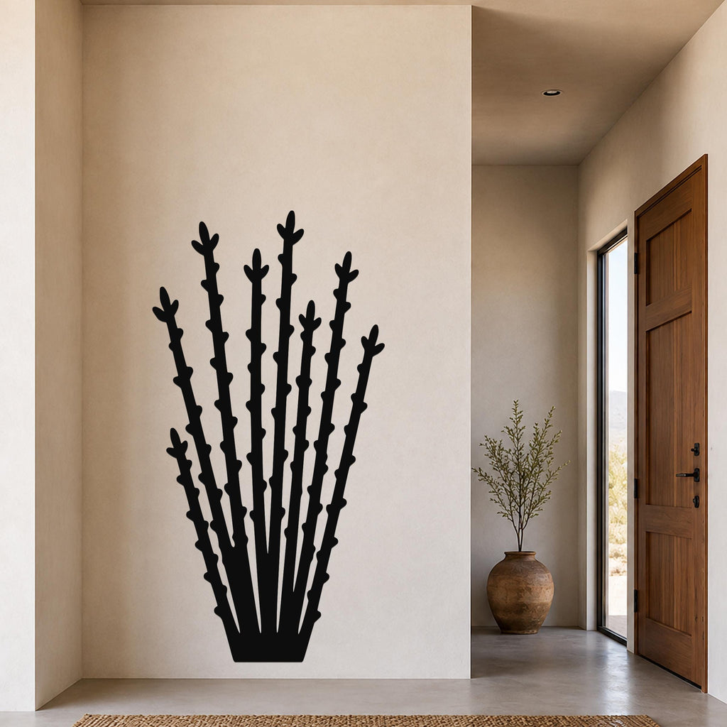 Black metal ocotillo wall art with tall, spiky branch cutouts, mounted on a beige wall in a modern entryway.