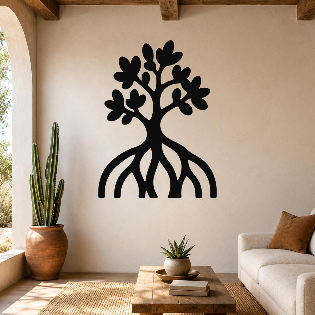 Black metal wall art in a tree silhouette with visible roots and leaf cutouts, mounted on a living room wall above a wooden coffee table.