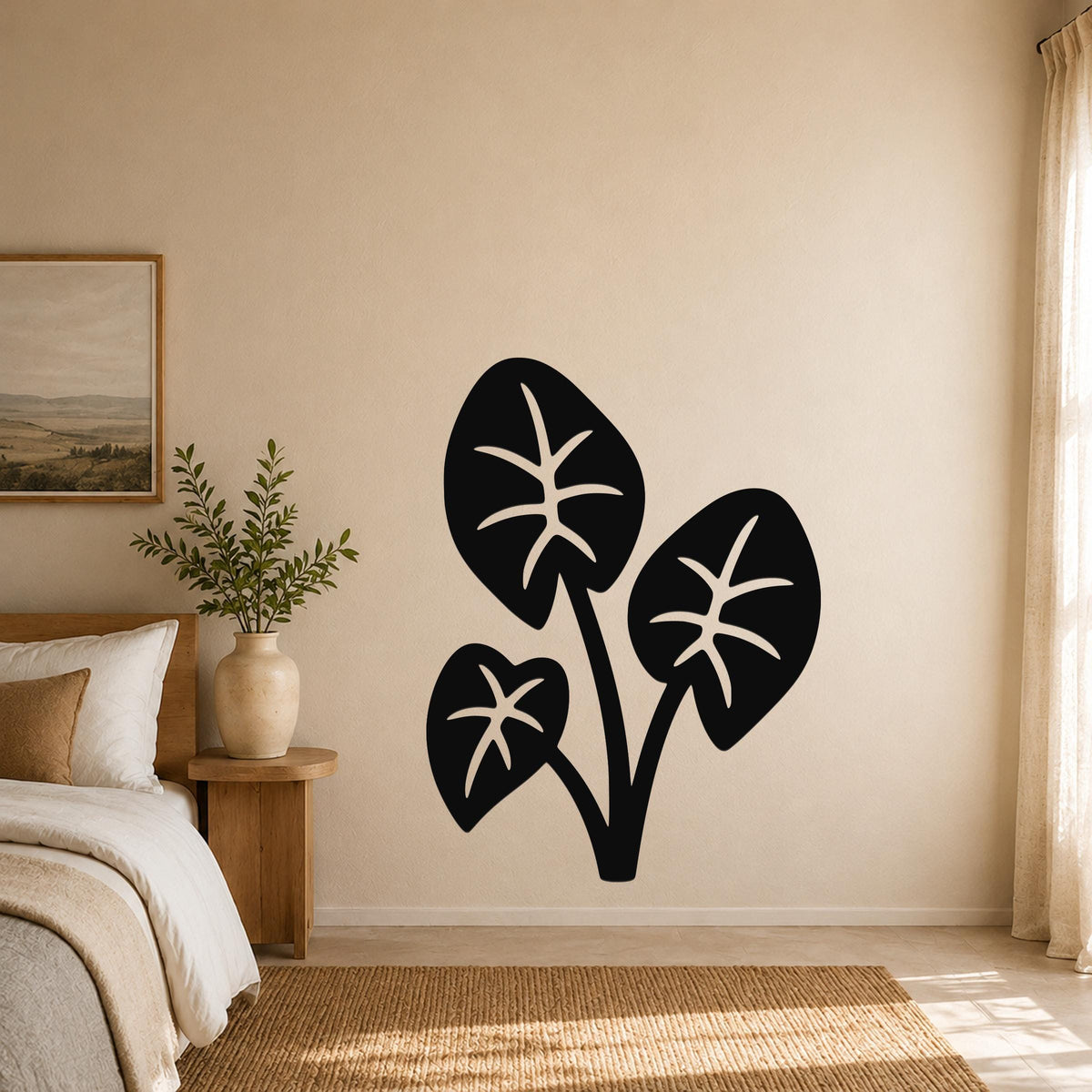 Black metal wall art in the shape of an elephant ear plant with three large leaves and internal vein cutouts, mounted on a beige bedroom wall above a woven rug.