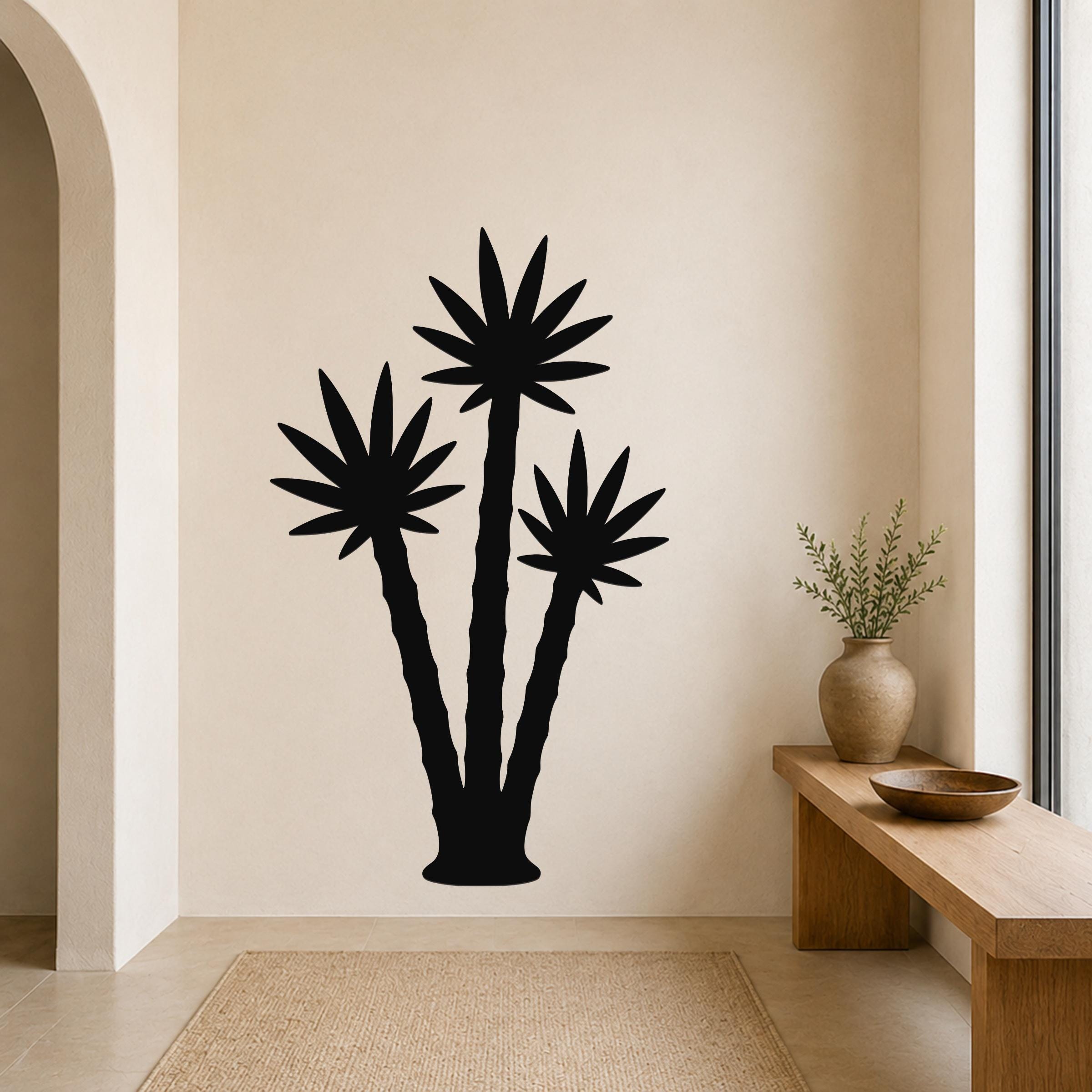 Black metal wall art featuring a silhouette of three palm trees, mounted on a beige wall above a wooden bench in a living room.
